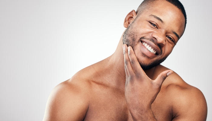 Studio portrait of a handsome young man posing against a white background.